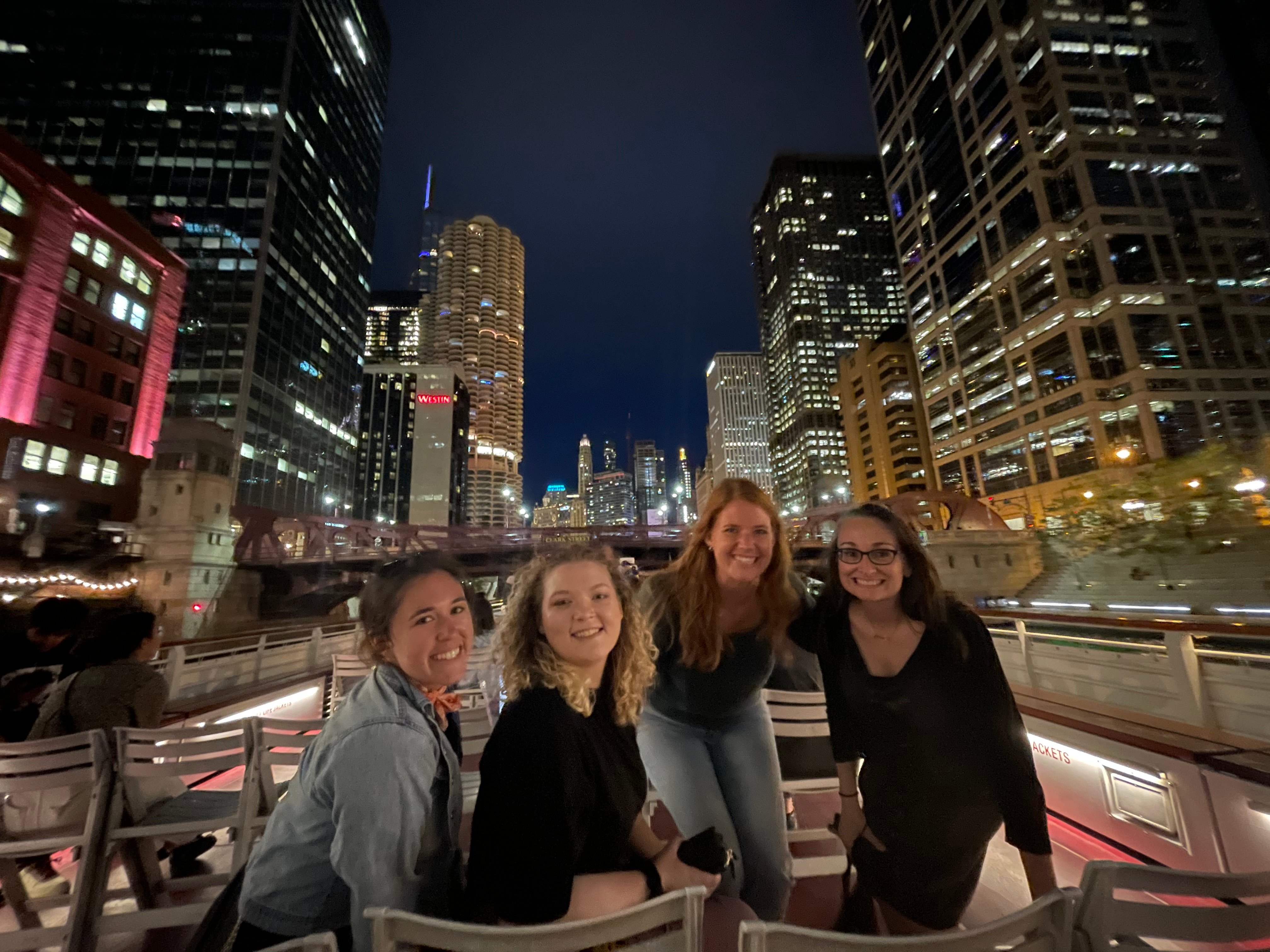 Four members of the Tier One team on a night architecture tour boat in Chicago