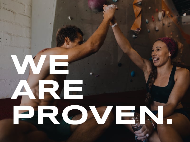 A man and woman high five in front of a rock wall. The words on the image read: We are proven.