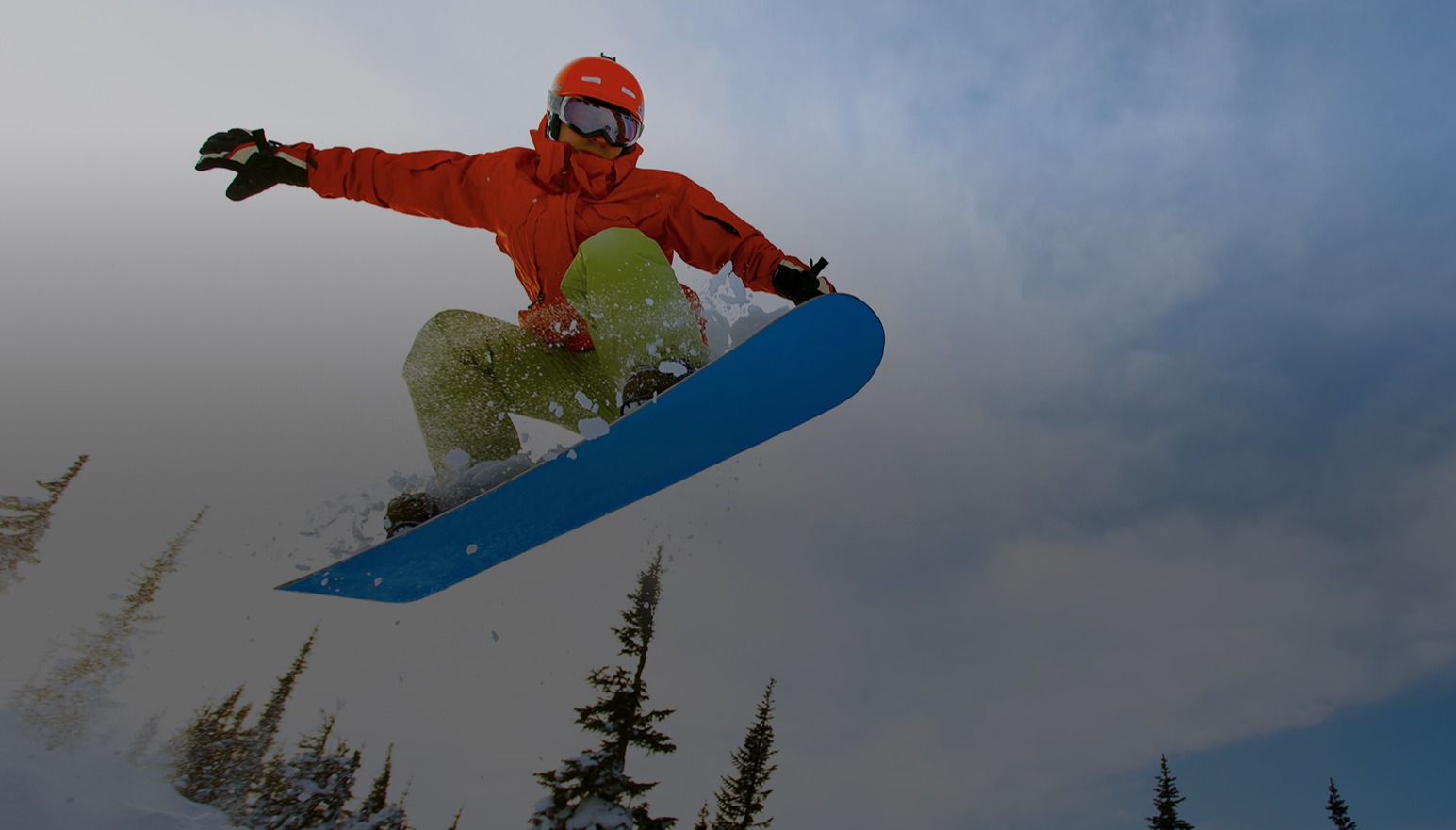 Snowboarder wearing bright clothing jumping