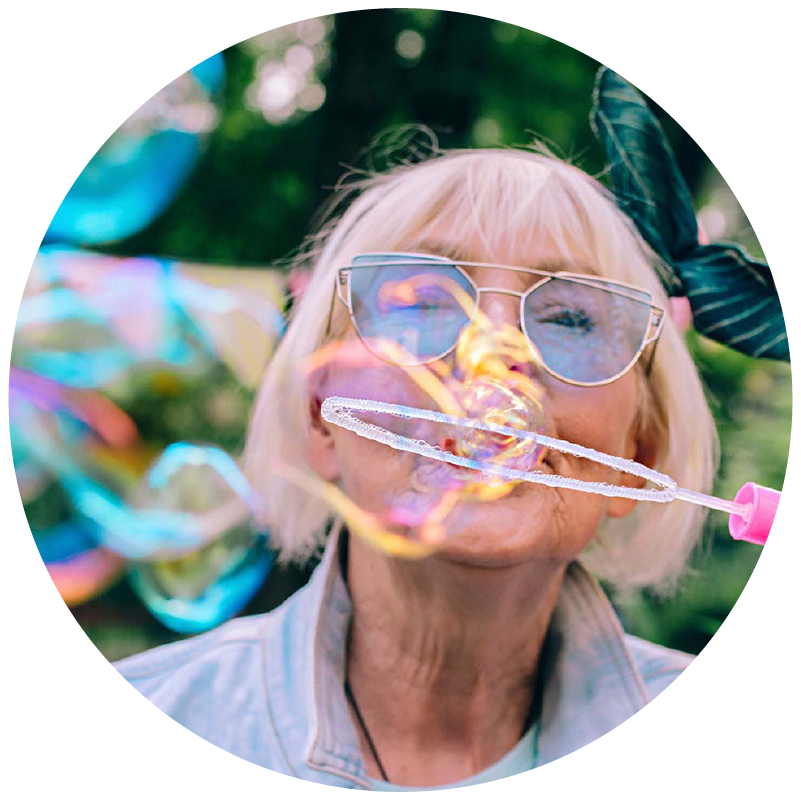 woman blows bubbles with butterfly behind her