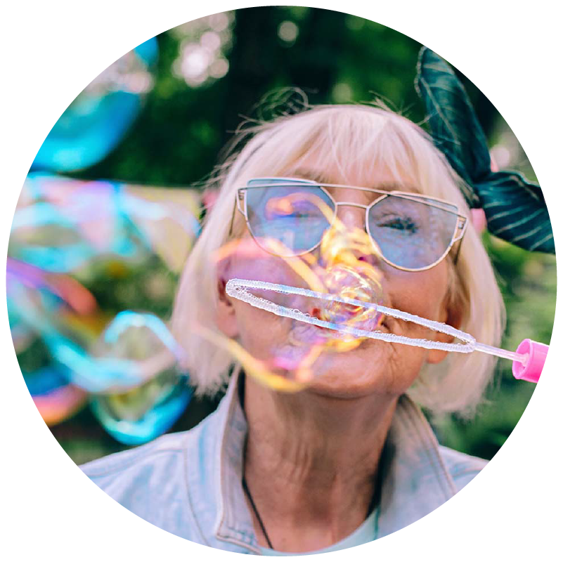 woman blows bubbles with butterfly behind her