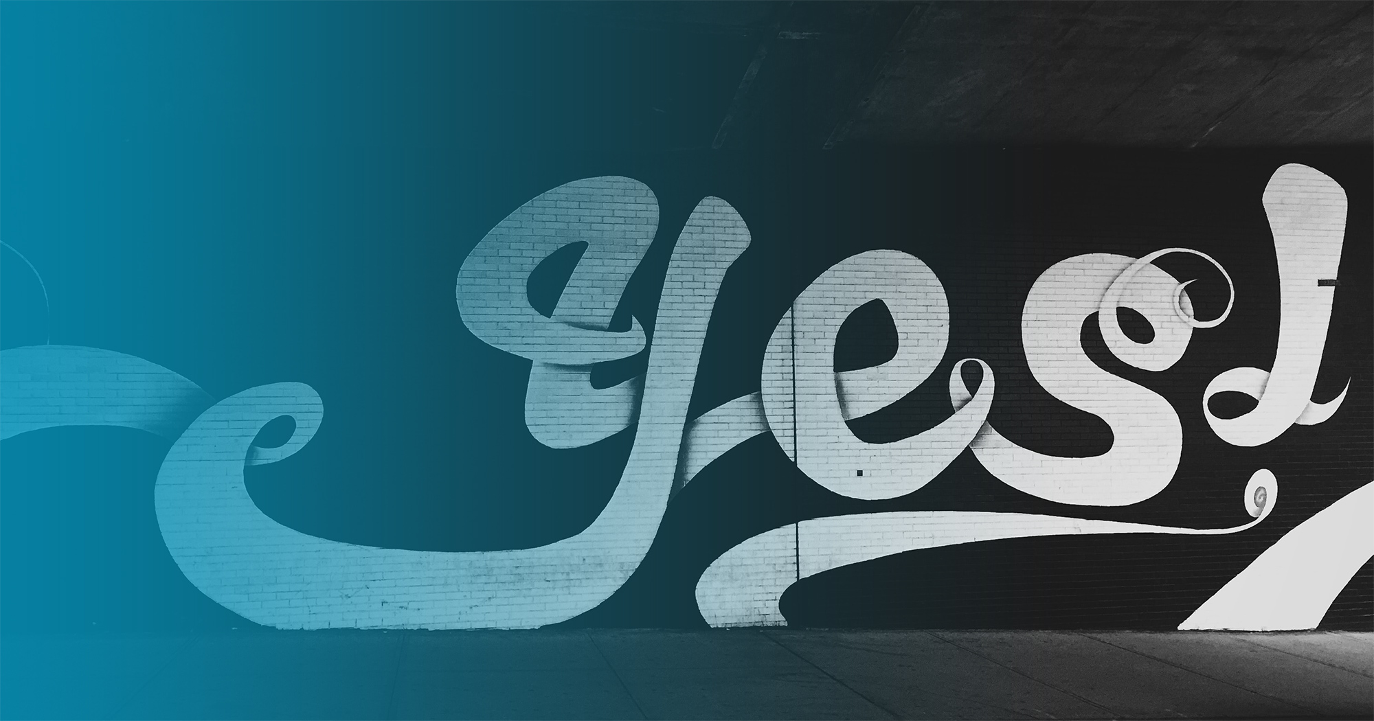 The word "Yes!" graffitied on a wall in black and white