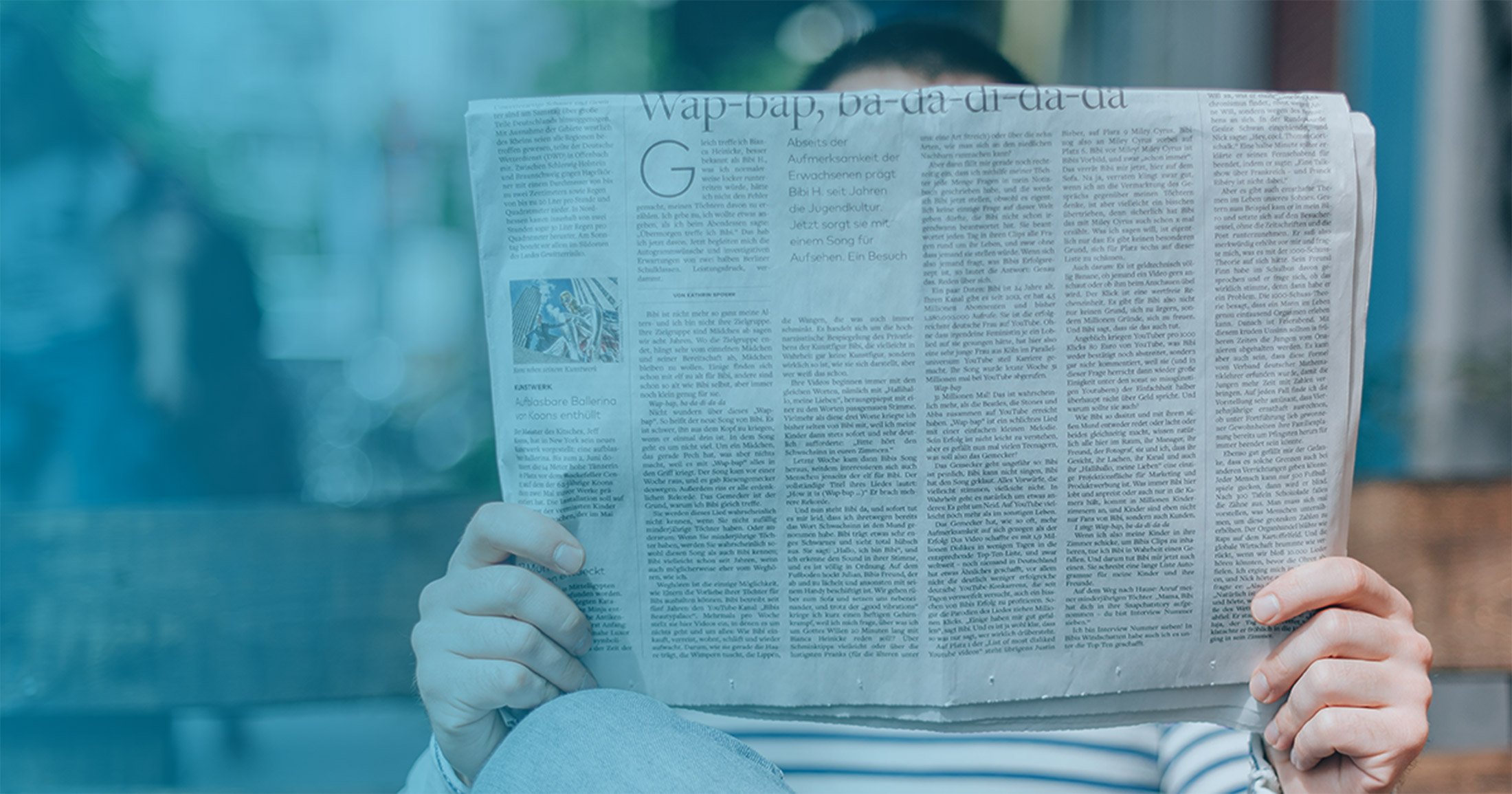 Person reading newspaper headlines