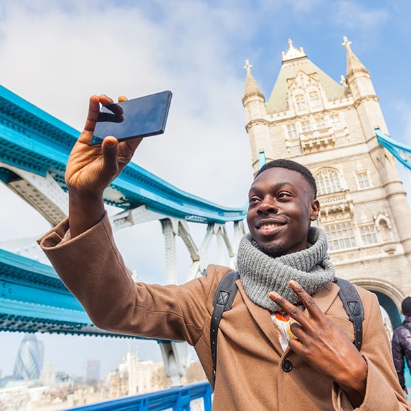 A young man takes a selfie on Tower Bridge in London
