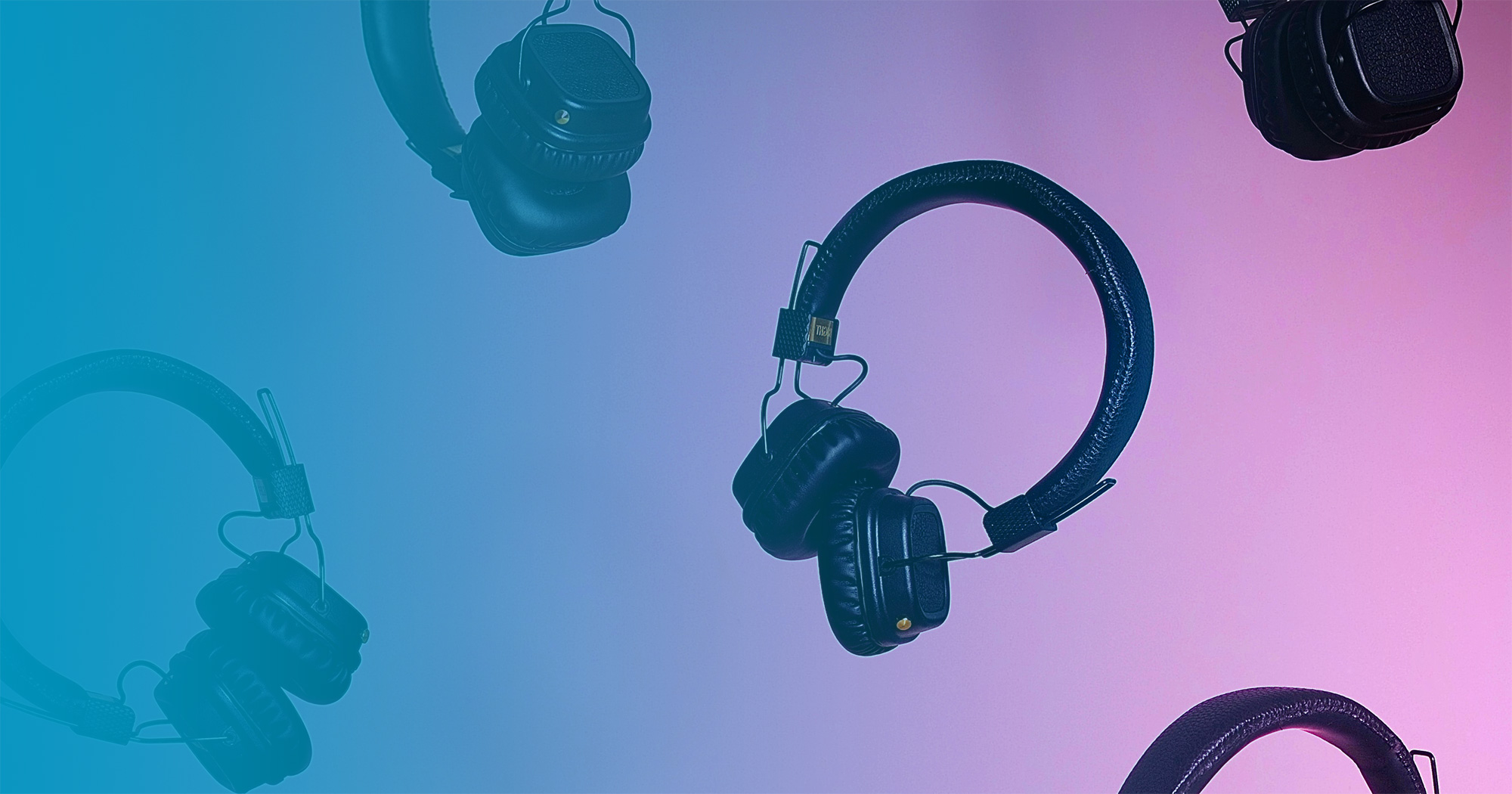 Multiple headphones floating on pink background