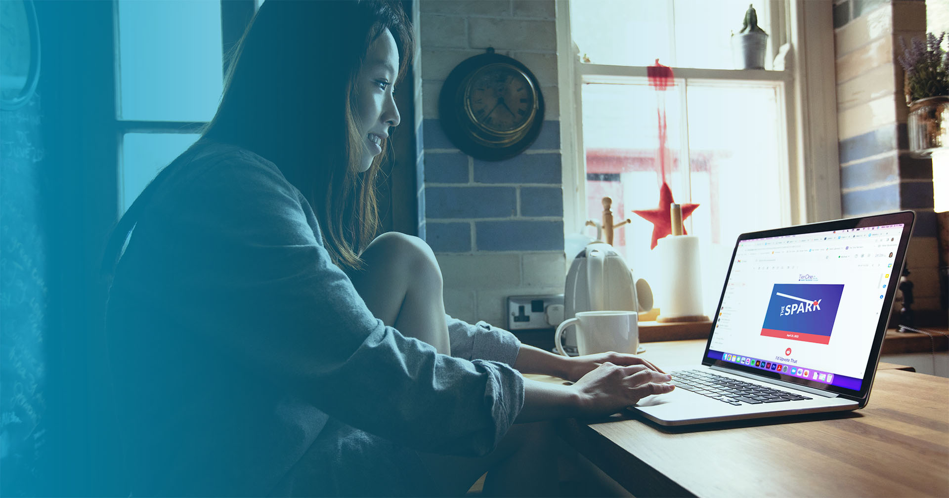 Woman looking at laptop screen showing "The Spark" newsletter
