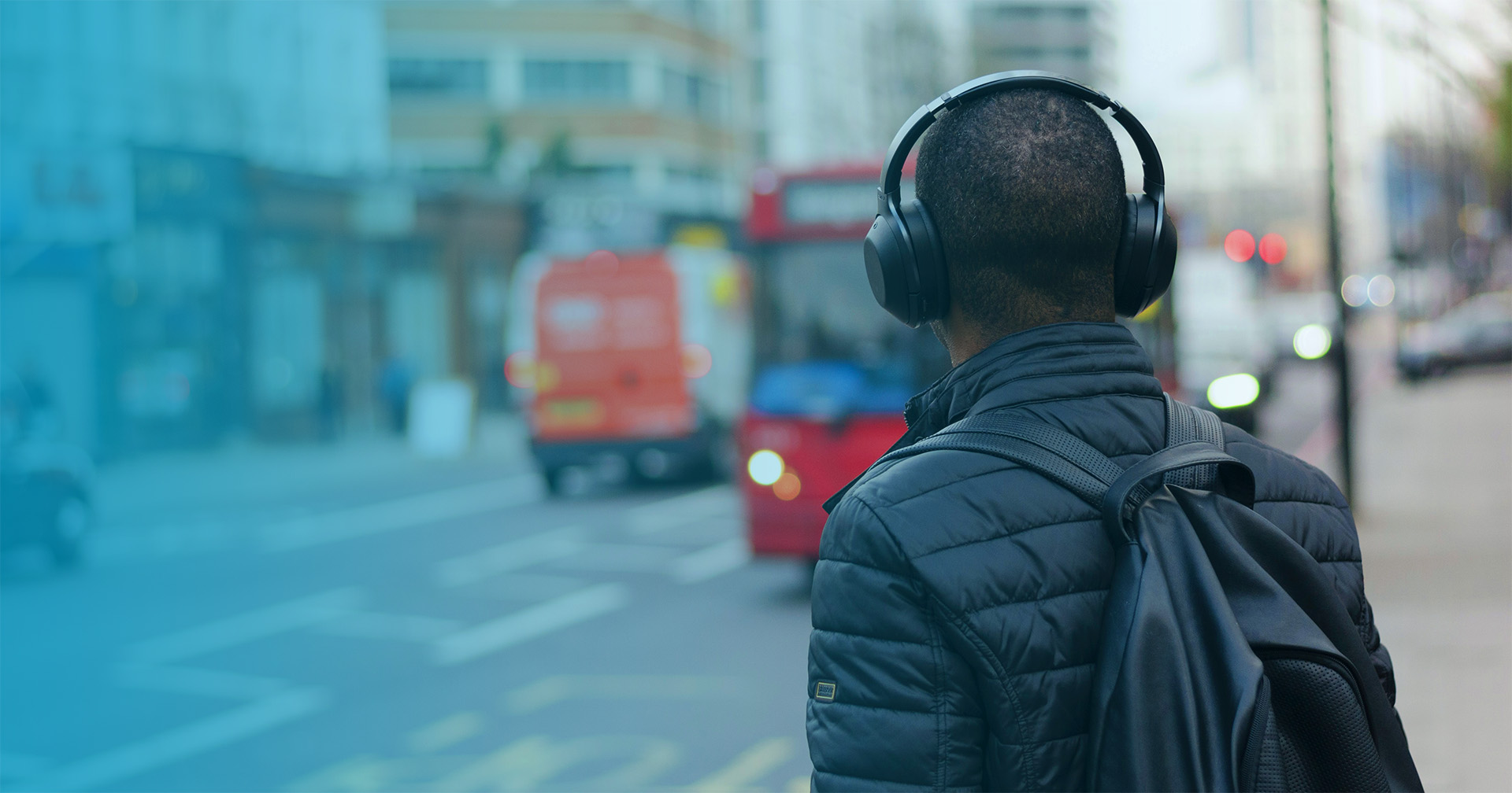 Man on a city street wearing over-the-ear headphones