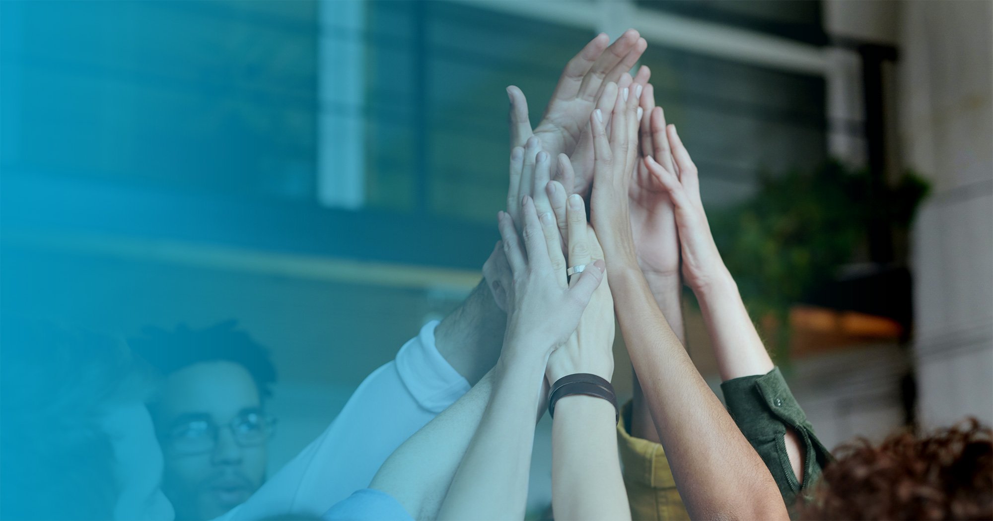 A group of diverse people high-fives.